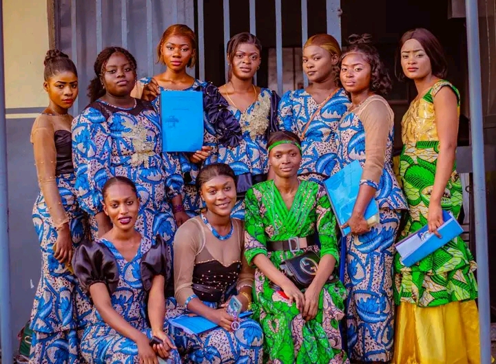 Graduates of a business training program holding folders together
